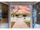 Stunning view from inside, showcasing backyard pool with rock feature, patio and lush landscape at 9325 Verlaine Ct, Las Vegas, NV 89145