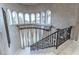 Grand staircase featuring a curved wall of windows and wrought iron railings, adding architectural interest at 9325 Verlaine Ct, Las Vegas, NV 89145