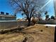 Spacious back yard featuring large mature tree, block wall fence, and a central stone fire pit at , Las Vegas, NV 89121