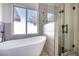 Bright bathroom featuring a modern shower and a free-standing tub near the window at 1006 Blue Lantern Dr, Henderson, NV 89015