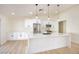 Bright kitchen featuring white cabinets, stainless steel appliances, and an island with a sink and quartz countertop at 1006 Blue Lantern Dr, Henderson, NV 89015