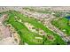 Aerial view of golf course in residential area, showcasing green fairways, sand traps and mature landscaping at 1059 Via Saint Lucia Pl, Henderson, NV 89011