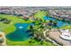 Aerial view of a lush golf course with serene lakes, palm trees, and surrounding residential community at 1059 Via Saint Lucia Pl, Henderson, NV 89011