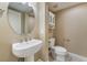 Small bathroom with a stylish pedestal sink and a toilet with built-in cabinet above it at 1059 Via Saint Lucia Pl, Henderson, NV 89011