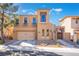 Two-story stucco home with a two car garage, arched doorway, and desert landscaping at 1059 Via Saint Lucia Pl, Henderson, NV 89011