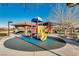 Community playground with colorful play structure, picnic shelter, and nearby trees on a sunny day at 1059 Via Saint Lucia Pl, Henderson, NV 89011