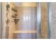 Walk in shower featuring granite walls, rainfall shower head, and bench at 1059 Via Saint Lucia Pl, Henderson, NV 89011