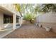 Gravel backyard space with a block wall, a tree, and three potted plants at 11204 Newbury Hills Ave, Las Vegas, NV 89138