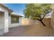 This backyard has low maintenance landscaping, a mature tree, and a block wall for added privacy at 11204 Newbury Hills Ave, Las Vegas, NV 89138