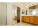 Bright bathroom featuring double sinks with wood cabinetry and mirrored sliding door at 11204 Newbury Hills Ave, Las Vegas, NV 89138