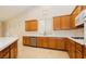 Well-lit kitchen with ample wood cabinetry, stainless dishwasher and gas range, plus white countertops at 11204 Newbury Hills Ave, Las Vegas, NV 89138