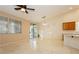 Tile-floored living area with large windows, a ceiling fan, and sliding patio doors at 11204 Newbury Hills Ave, Las Vegas, NV 89138