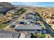 An aerial view reveals a neighborhood of gray-roofed homes nestled against mountains in the distance at 11296 Villa Bellagio Dr, Las Vegas, NV 89141