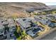 This aerial shows the backyard pool and patios of a gray-roofed house located near the desert mountains at 11296 Villa Bellagio Dr, Las Vegas, NV 89141