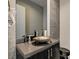 Contemporary powder room with a stone vessel sink, designer fixtures, and elegant tile accent wall at 11296 Villa Bellagio Dr, Las Vegas, NV 89141