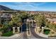 Inviting community entrance with palm trees, lush landscaping, and manicured lawns at 11296 Villa Bellagio Dr, Las Vegas, NV 89141