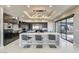 Modern kitchen with dark cabinetry, stainless steel appliances, an island with seating, and sliding doors to the patio at 11296 Villa Bellagio Dr, Las Vegas, NV 89141