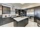 Modern kitchen featuring dark wood cabinets, stainless steel appliances, and a center island with a white countertop at 11296 Villa Bellagio Dr, Las Vegas, NV 89141