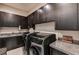 Well-equipped laundry room featuring modern appliances, granite countertops, and custom cabinets at 11296 Villa Bellagio Dr, Las Vegas, NV 89141