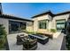 Modern patio with cushioned seating around a fireplace and sliding glass doors to the interior at 11296 Villa Bellagio Dr, Las Vegas, NV 89141