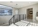 Modern staircase with a crystal chandelier, large windows, and sleek metal railings leading to the upper level at 11296 Villa Bellagio Dr, Las Vegas, NV 89141