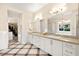 Elegant bathroom featuring dual vanities, a soaking tub, and stylish tile flooring at 12217 Tempestad Ave, Las Vegas, NV 89138