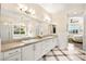 Bright bathroom with dual sinks, modern fixtures, and tub with window at 12217 Tempestad Ave, Las Vegas, NV 89138