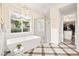 Bright bathroom featuring a soaking tub, walk-in shower, decorative lighting and floors at 12217 Tempestad Ave, Las Vegas, NV 89138