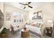 Charming bedroom with a daybed, accent chair, plantation shutters, and warm neutral tones for a relaxing ambiance at 12217 Tempestad Ave, Las Vegas, NV 89138