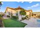 Well-manicured backyard with a pool, outdoor kitchen, and lush green turf at 12217 Tempestad Ave, Las Vegas, NV 89138