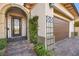 Exterior showing a home's arched front entrance, landscaped yard and a two-car garage at 12217 Tempestad Ave, Las Vegas, NV 89138