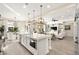 Spacious kitchen with white cabinetry, a large island, pendant lighting, and an open layout to the living area at 12217 Tempestad Ave, Las Vegas, NV 89138