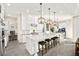 Bright kitchen with white cabinets, a large island with seating, and pendant lighting, open to the dining area at 12217 Tempestad Ave, Las Vegas, NV 89138