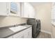 Functional laundry room featuring modern washer and dryer, ample counter space, and plenty of cabinet storage at 12217 Tempestad Ave, Las Vegas, NV 89138