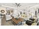 Open living room with a coffered ceiling and neutral decor, seamlessly connected to a modern white kitchen at 12217 Tempestad Ave, Las Vegas, NV 89138