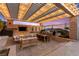 Outdoor kitchen and patio area featuring a built-in grill, fireplace, and comfortable seating beneath a pergola at 12217 Tempestad Ave, Las Vegas, NV 89138