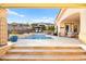 Relaxing backyard featuring a shimmering pool with a spa, a shaded patio, and a beautiful outdoor living space at 12217 Tempestad Ave, Las Vegas, NV 89138