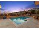 Beautiful pool with a spa and fire bowls set against a scenic hillside backdrop and twilight sky at 12217 Tempestad Ave, Las Vegas, NV 89138