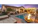 A luxurious backyard featuring a stunning pool with fire bowls and a covered outdoor living area at 12217 Tempestad Ave, Las Vegas, NV 89138