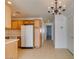 A well-lit kitchen area featuring tile floors, wooden cabinets, and essential appliances at 2049 Audrey Hepburn St, Las Vegas, NV 89142