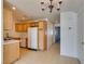 A well-lit kitchen area featuring tile floors, wooden cabinets, and essential appliances at 2049 Audrey Hepburn St, Las Vegas, NV 89142