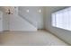 Bright living room featuring high ceilings, tile flooring, and a staircase at 2049 Audrey Hepburn St, Las Vegas, NV 89142