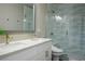 Modern bathroom featuring a double vanity, wave-patterned tile and a glass-enclosed shower at 2176 De Narvik Dr, Henderson, NV 89044