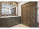 Modern bathroom with double vanity, decorative mosaic tile accent wall, and a rustic barn door at 2176 De Narvik Dr, Henderson, NV 89044