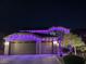 Festive two-story home featuring a three car garage and adorned with vibrant purple and pink holiday lights at 2176 De Narvik Dr, Henderson, NV 89044