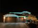 Festive two-story home featuring a three car garage and adorned with vibrant green and white holiday lights at 2176 De Narvik Dr, Henderson, NV 89044