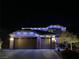 Festive two-story home adorned with colorful holiday lights at night at 2176 De Narvik Dr, Henderson, NV 89044