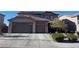 Inviting two-story home featuring a spacious three-car garage and a well-maintained front yard at 2176 De Narvik Dr, Henderson, NV 89044