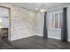 Modern living room with hardwood floors, a brick wall, and a stylish chandelier at 2176 De Narvik Dr, Henderson, NV 89044