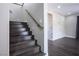 Staircase with wooden steps and handrail leading to a hallway with brick accent wall at 2176 De Narvik Dr, Henderson, NV 89044